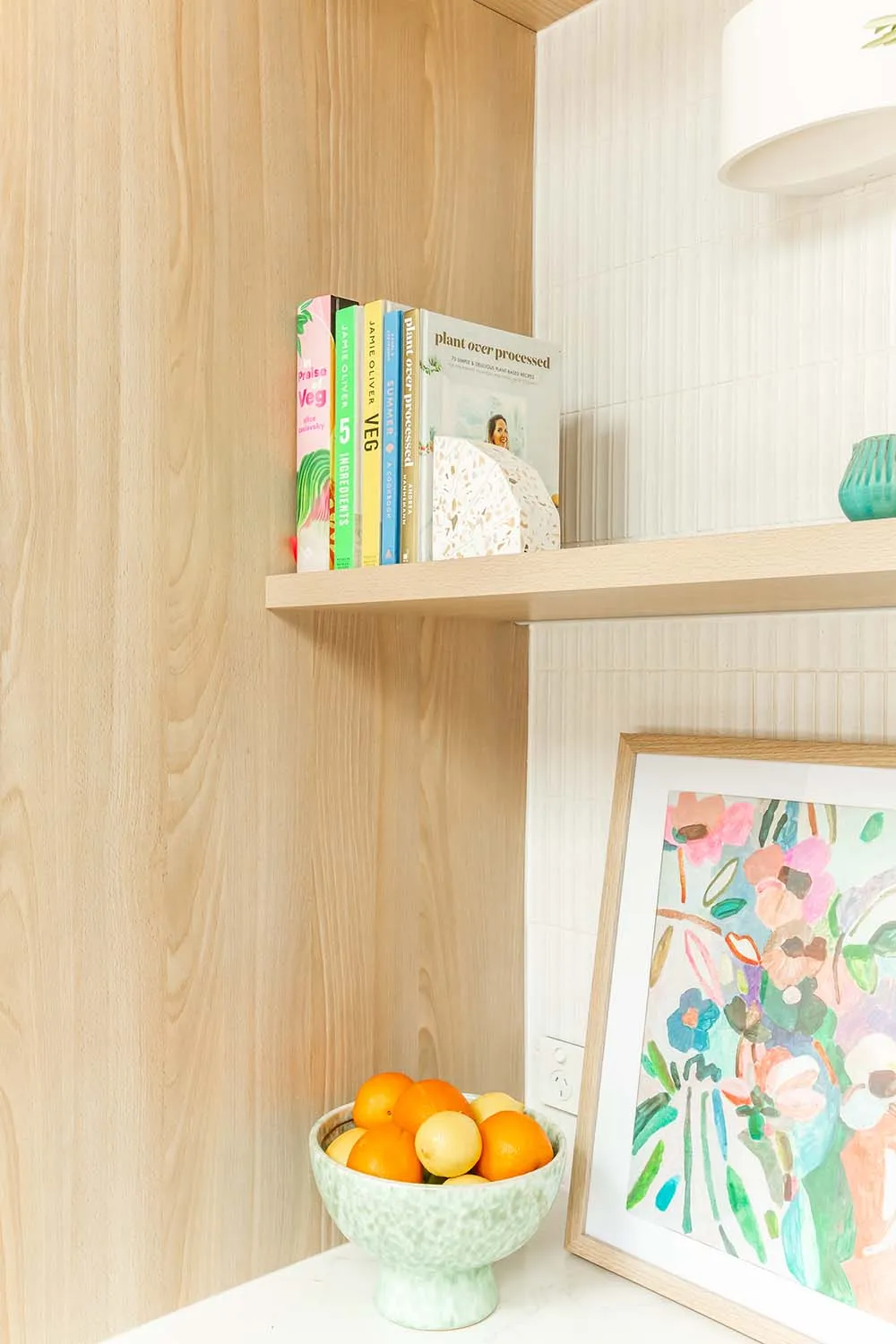Timber kitchen shelves styled with books, ceramics and a floral print